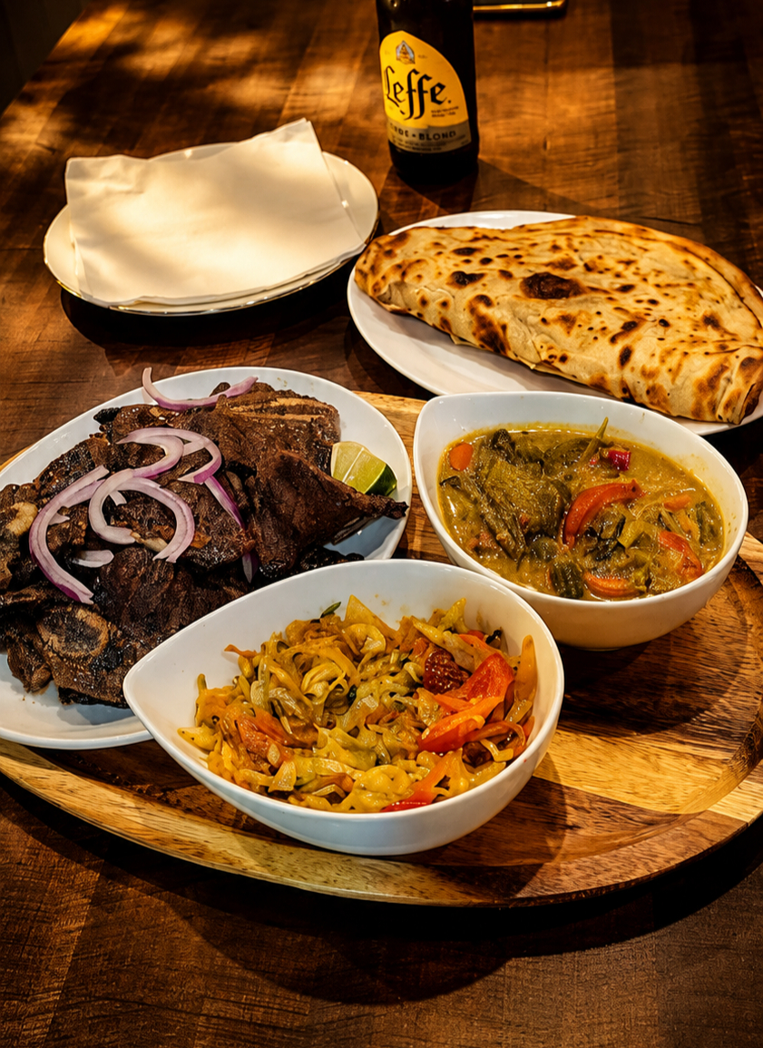 Grilled nyama choma with chapati, mchuzi and cabbage on a wooden board